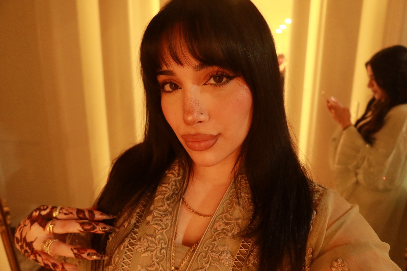 Noor in a warm golden portrait wearing henna